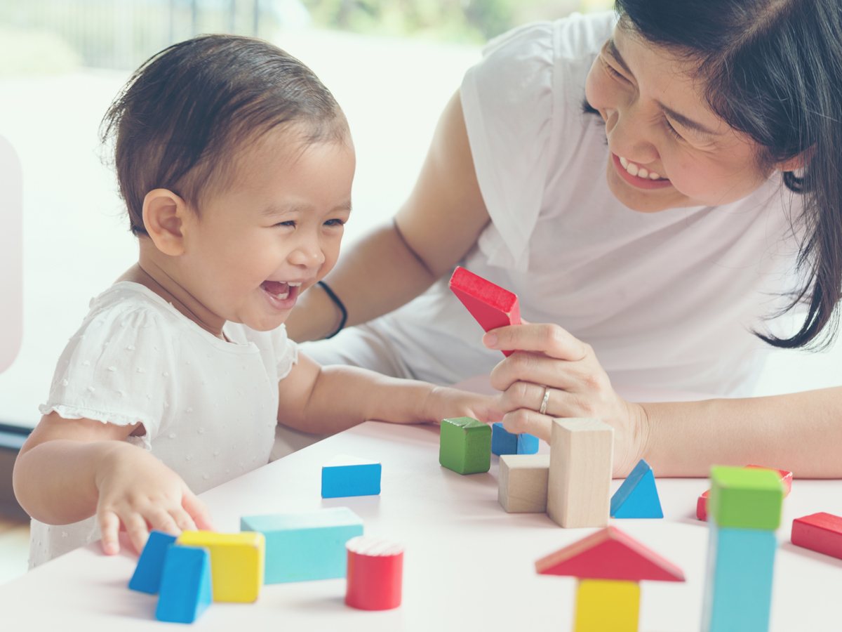 mother son play with wooden blocks