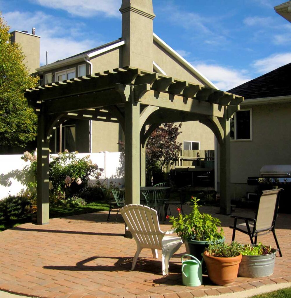 Freestanding pergola with custom sage green stain over brick patio