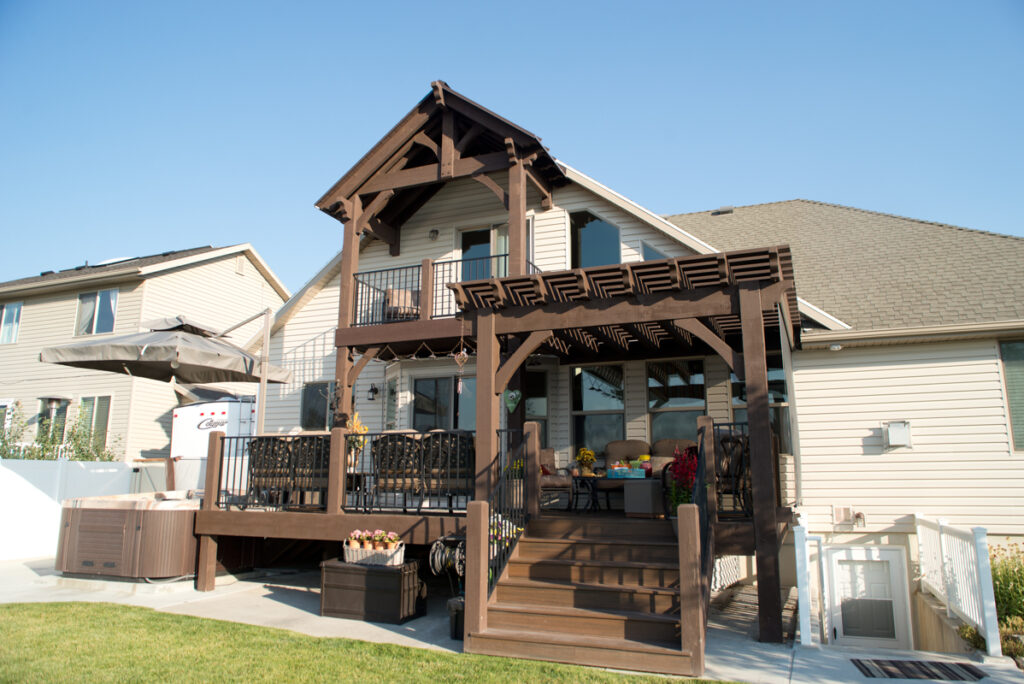 Two-story home with a Rich Cordoba-stained timber frame pergola and elevated deck seating area