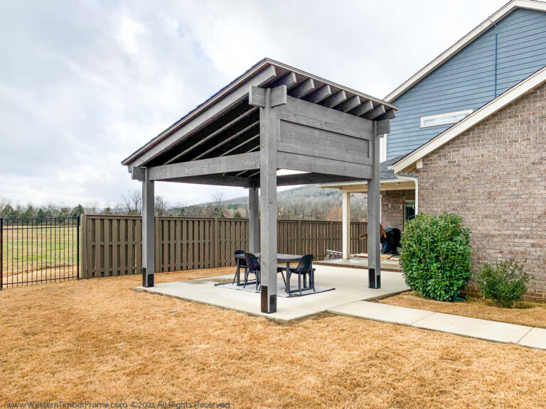 Gray timber frame cabana with shed-style roof, solid privacy shade panels, and TimberClad® metal accents by Western Timber Frame
