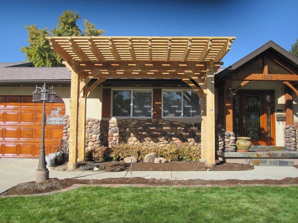Timber frame pergola with extended cantilevered roof and natural wood stain by Western Timber Frame