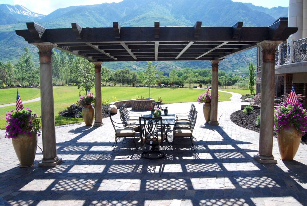 Western Timber Frame pergola with Greek-Roman Tuscany marble-style posts over an outdoor dining room.
