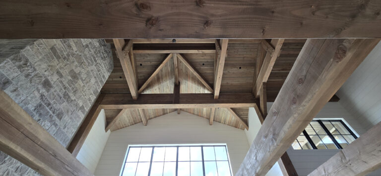 nterior view of luxury building featuring Western Timber Frame™ exposed timber frame beams with a tongue-and-groove gabled vaulted ceiling