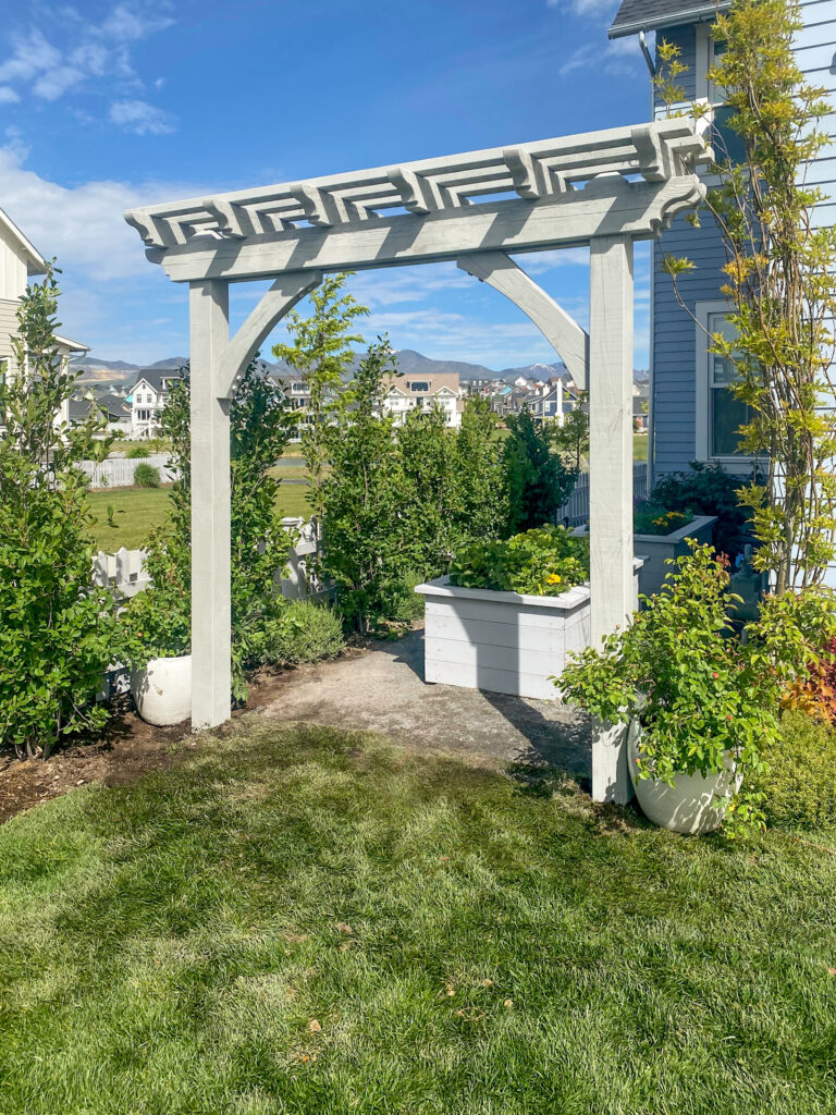 Alt Text: Custom-stained garden arbor with planter boxes and decorative beam accents