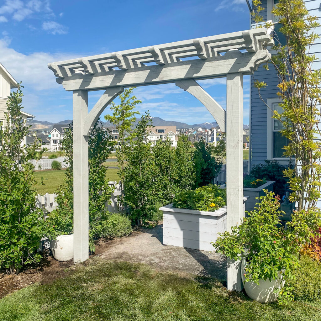 Alt Text: Custom-stained garden arbor with planter boxes and decorative beam accents