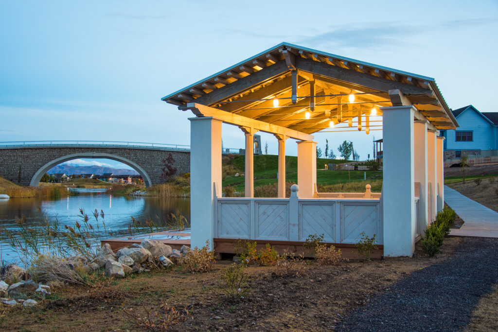 Island-style pavilion with TimberVolt® lighting at dusk by the lake