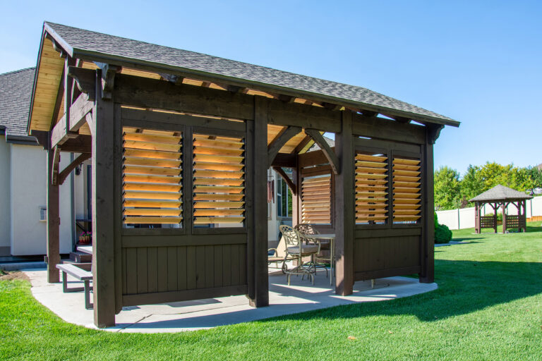 Timber pavilion with adjustable louvered shutters and outdoor dining area, with matching gazebo in the yard
