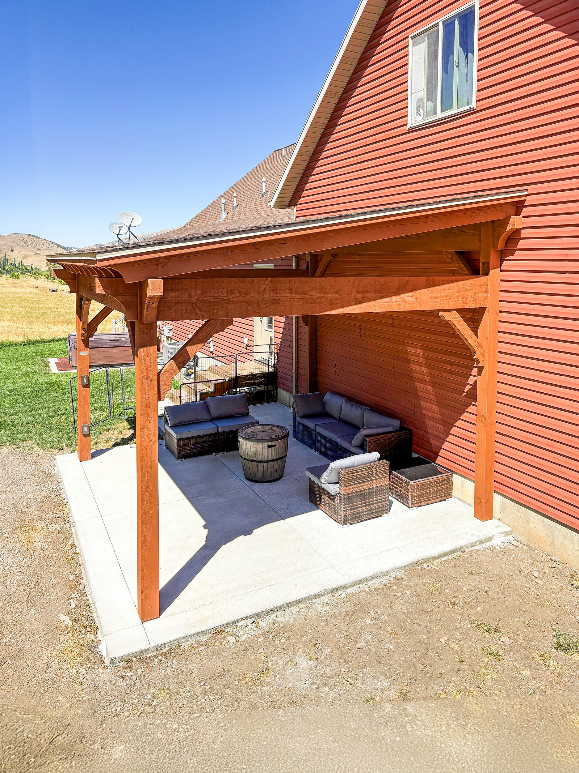 Overhead view of a 14×16 timber frame cabana with shed roof and TimberVolt® power post over a furnished concrete patio.
