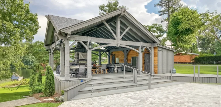 timber frame pavilion with gable roof and elevated deck in landscaped backyard