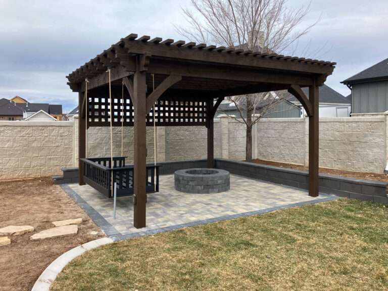 Freestanding backyard pergola installation featuring lattice privacy panels, integrated swing seating, and a paved patio foundation.